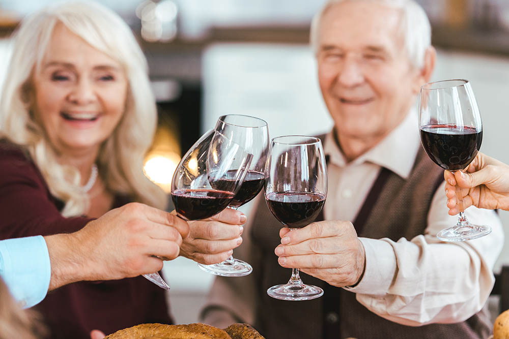 senior couple clinking glasses with family during holiday celebr